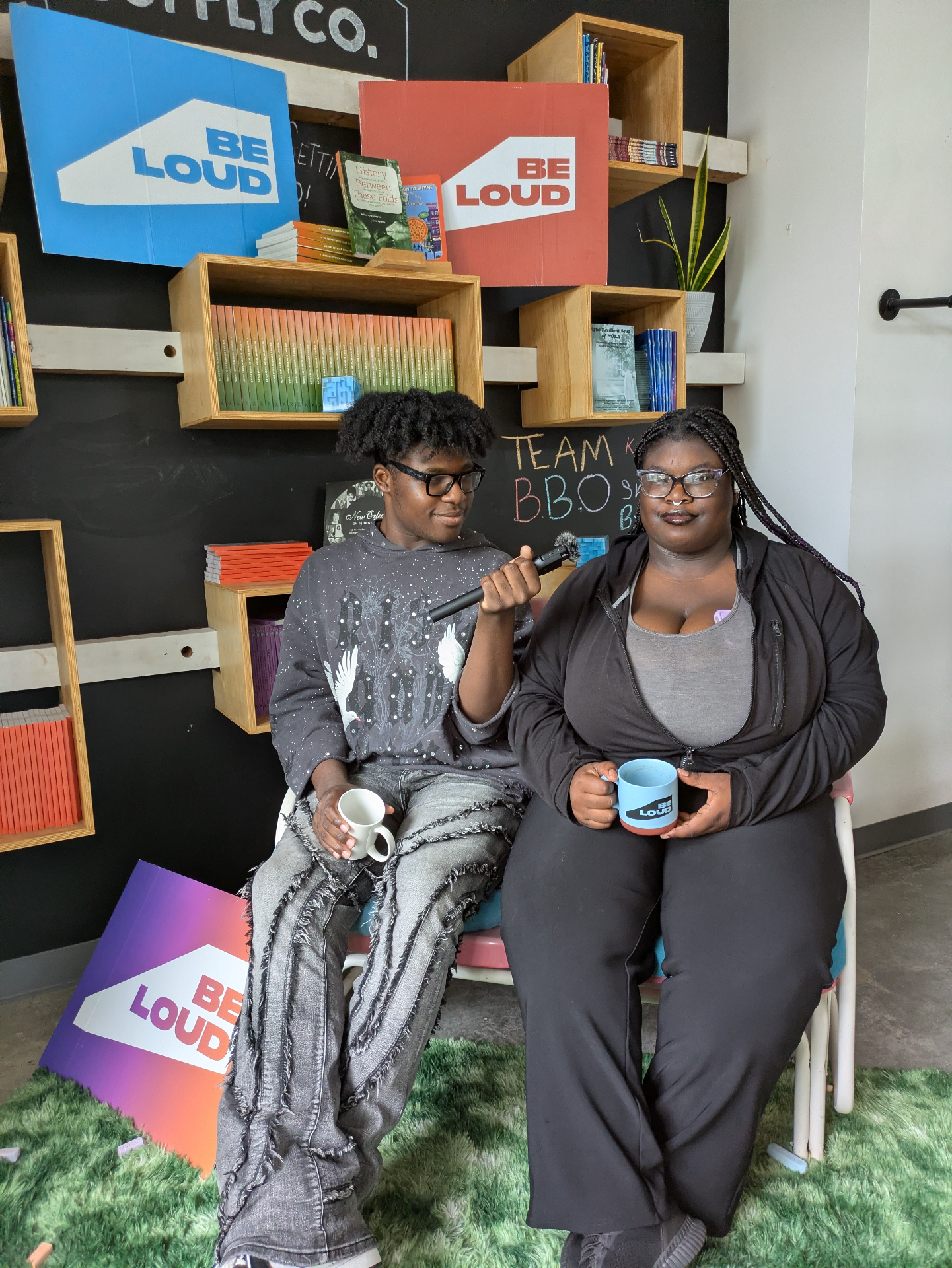 Teens posing with Be Loud mugs in the studio