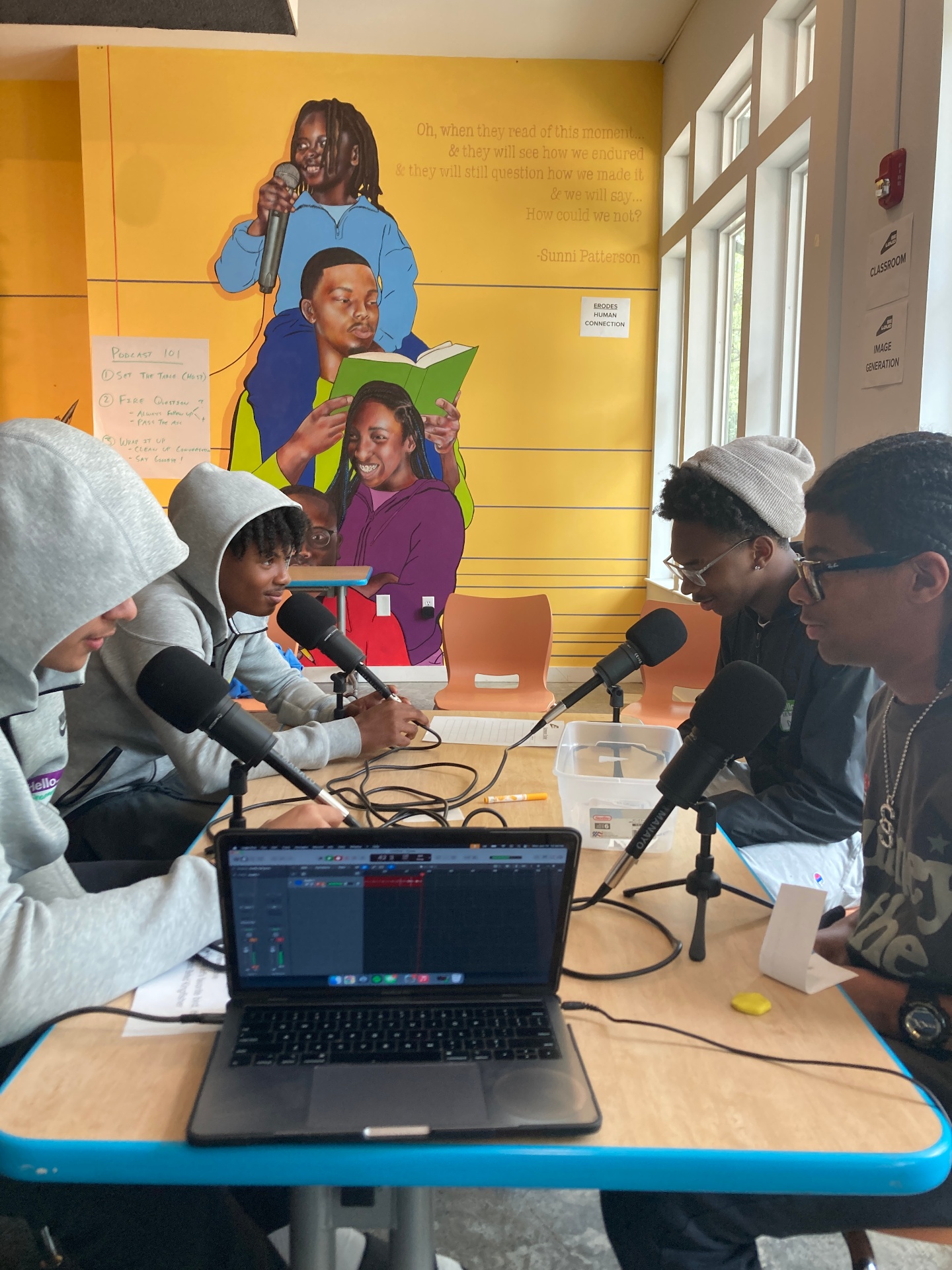 Cohort recording a podcast around the table